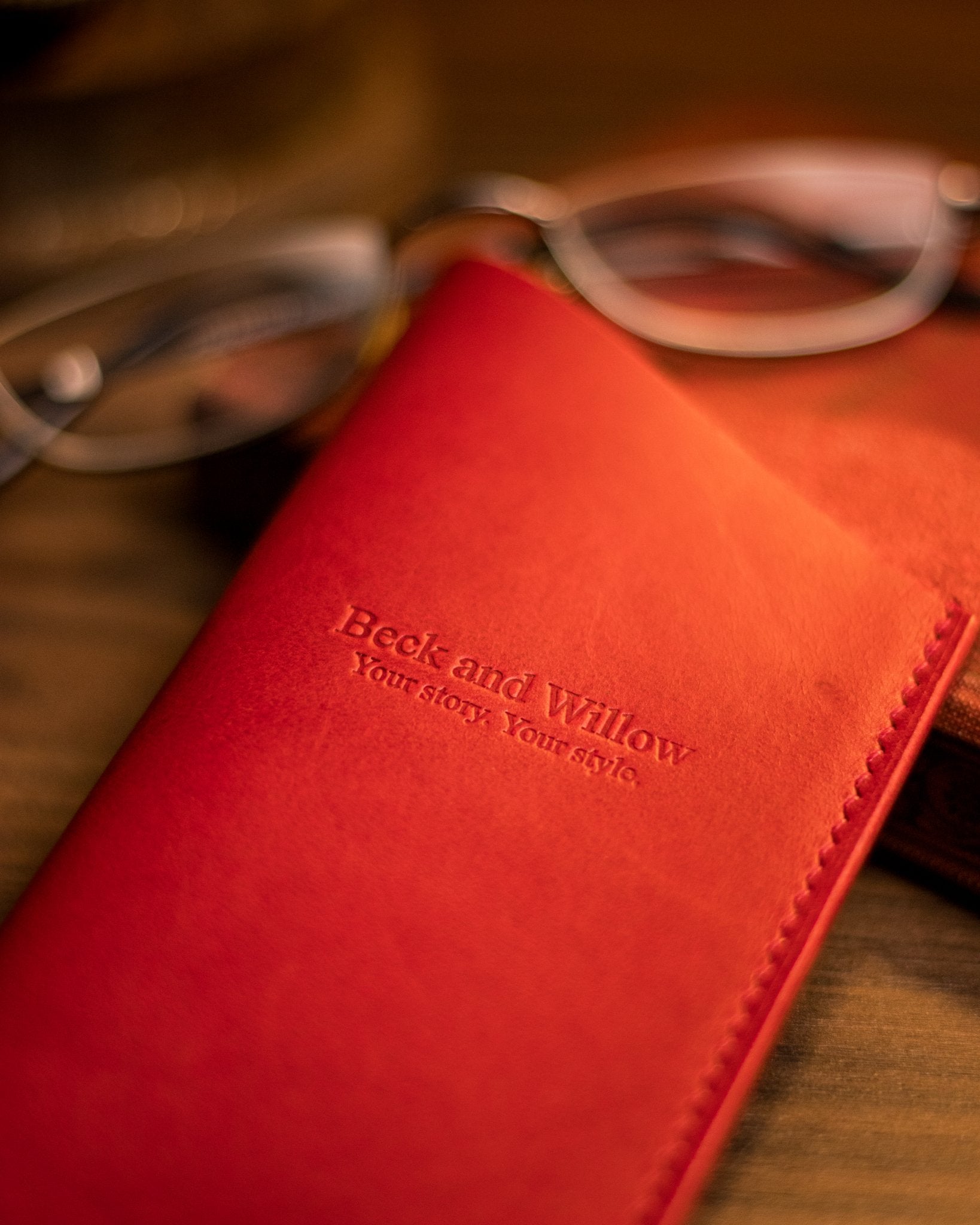 Close up photo of brand logo on red leather glasses sleeve