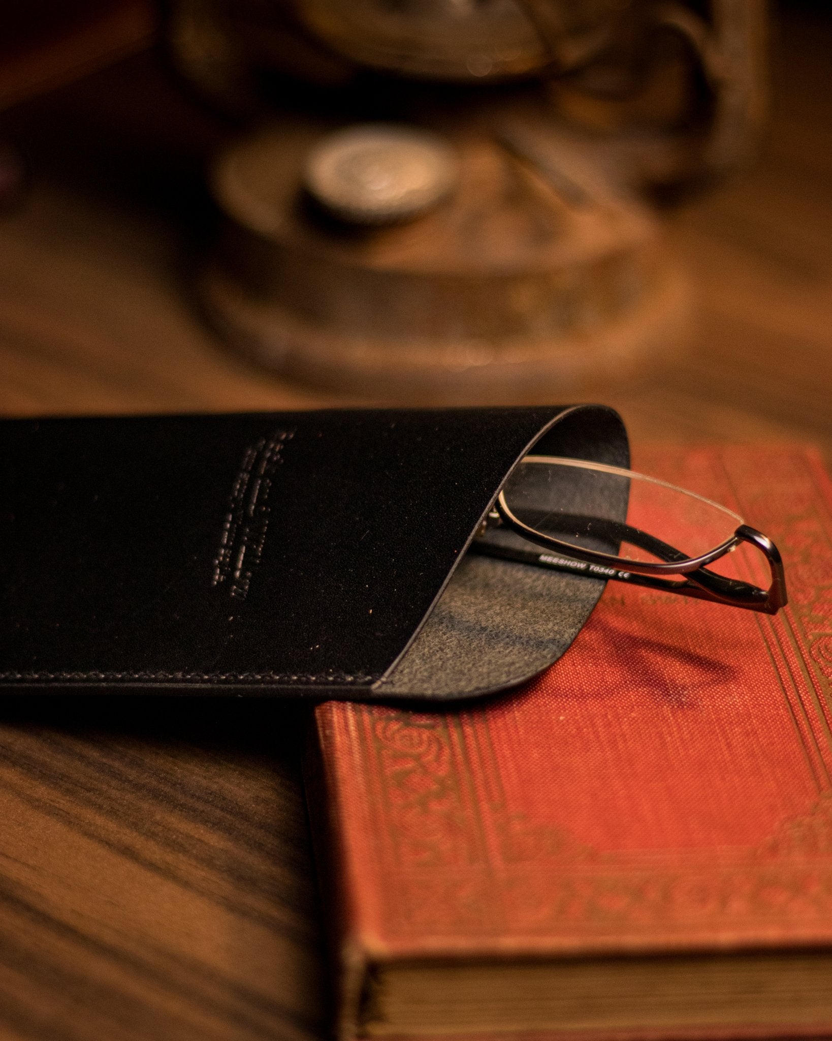 Close photo of glasses peaking out of a black italian leather glasses case