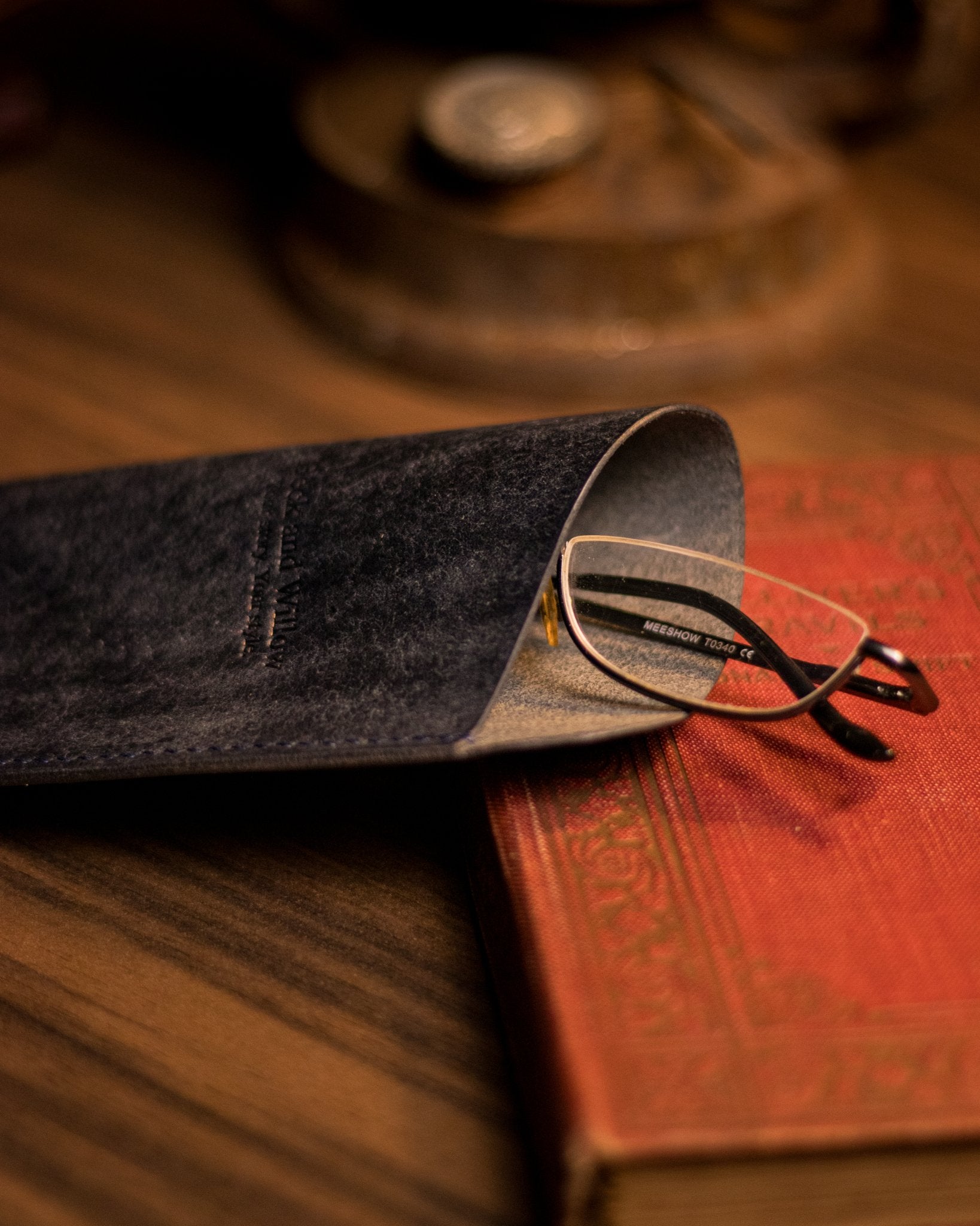 close photo of glasses peaking out of a navy italian leather glasses case