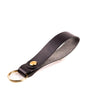 black italian leather keyring with brass hardware on a white background