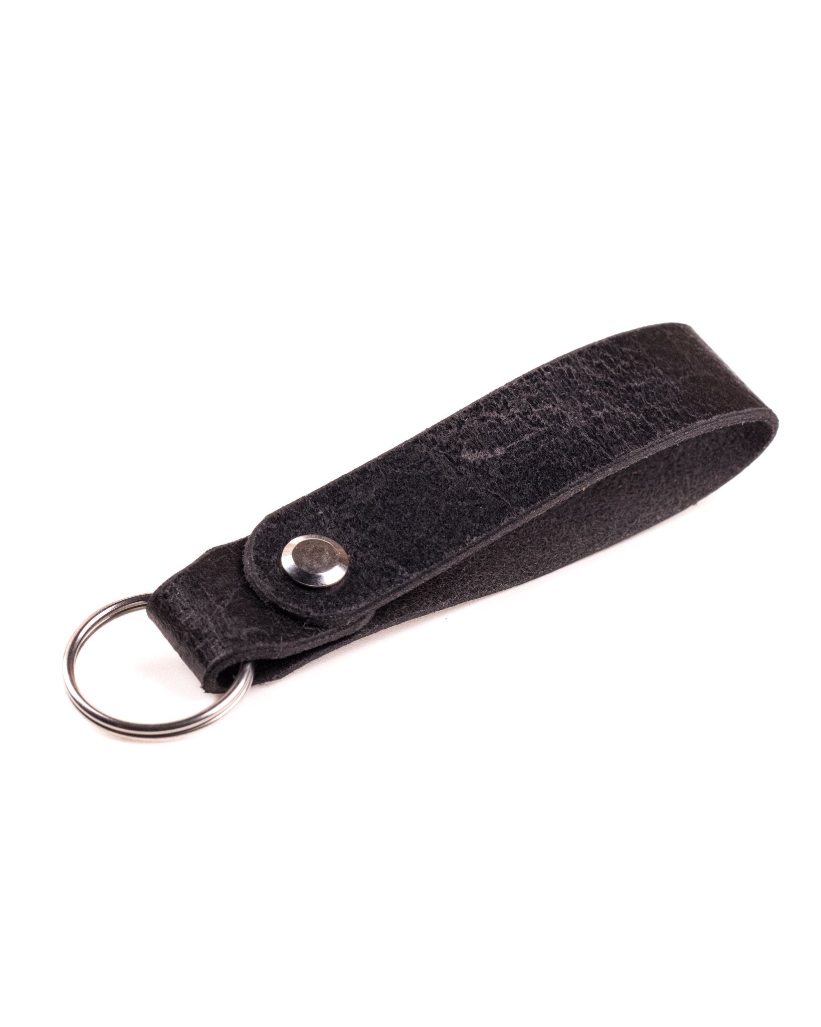 Black Distressed leather keyring with brass hardware on a white background