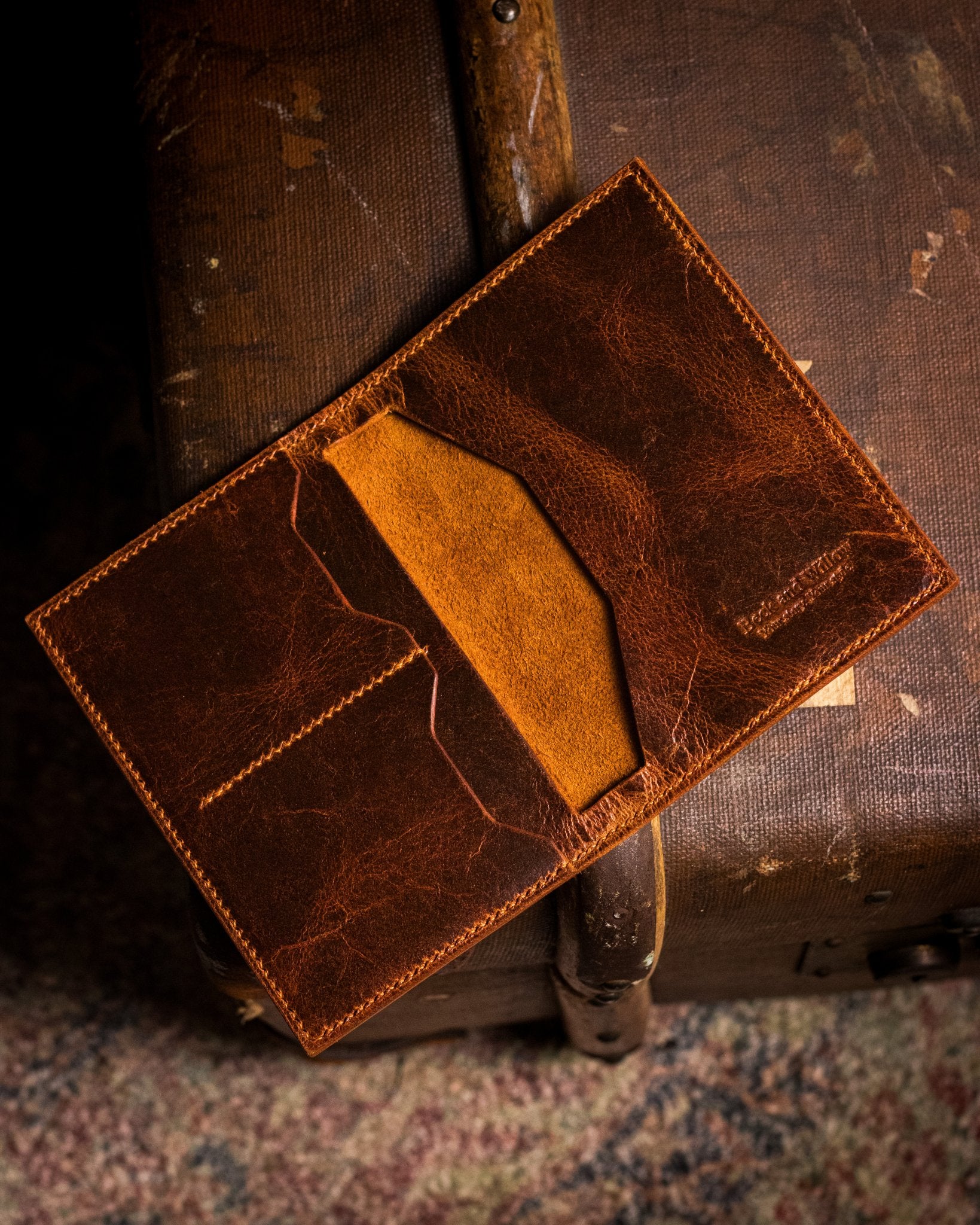 distressed tan passport holder on a travel trunk