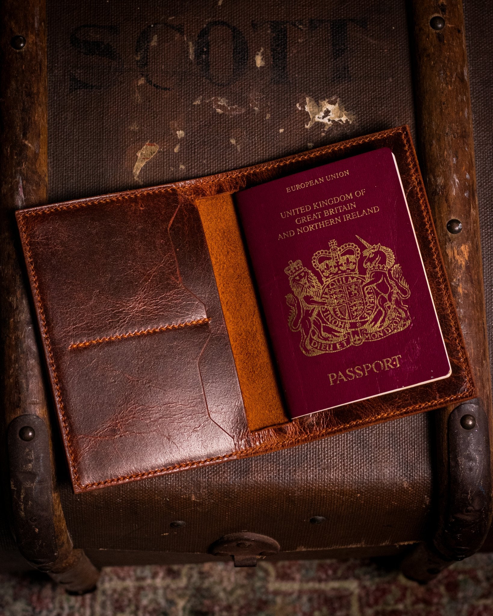 british passport in a leather cover on a wooden trunk