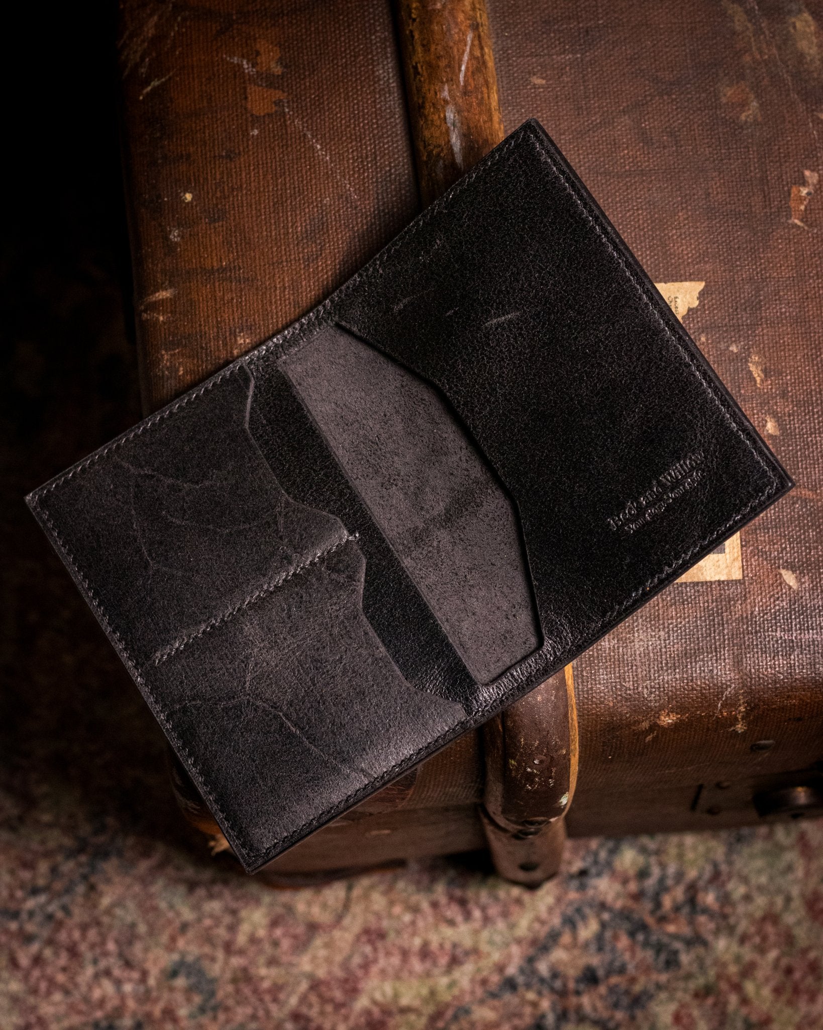 distressed black passport holder on a travel trunk