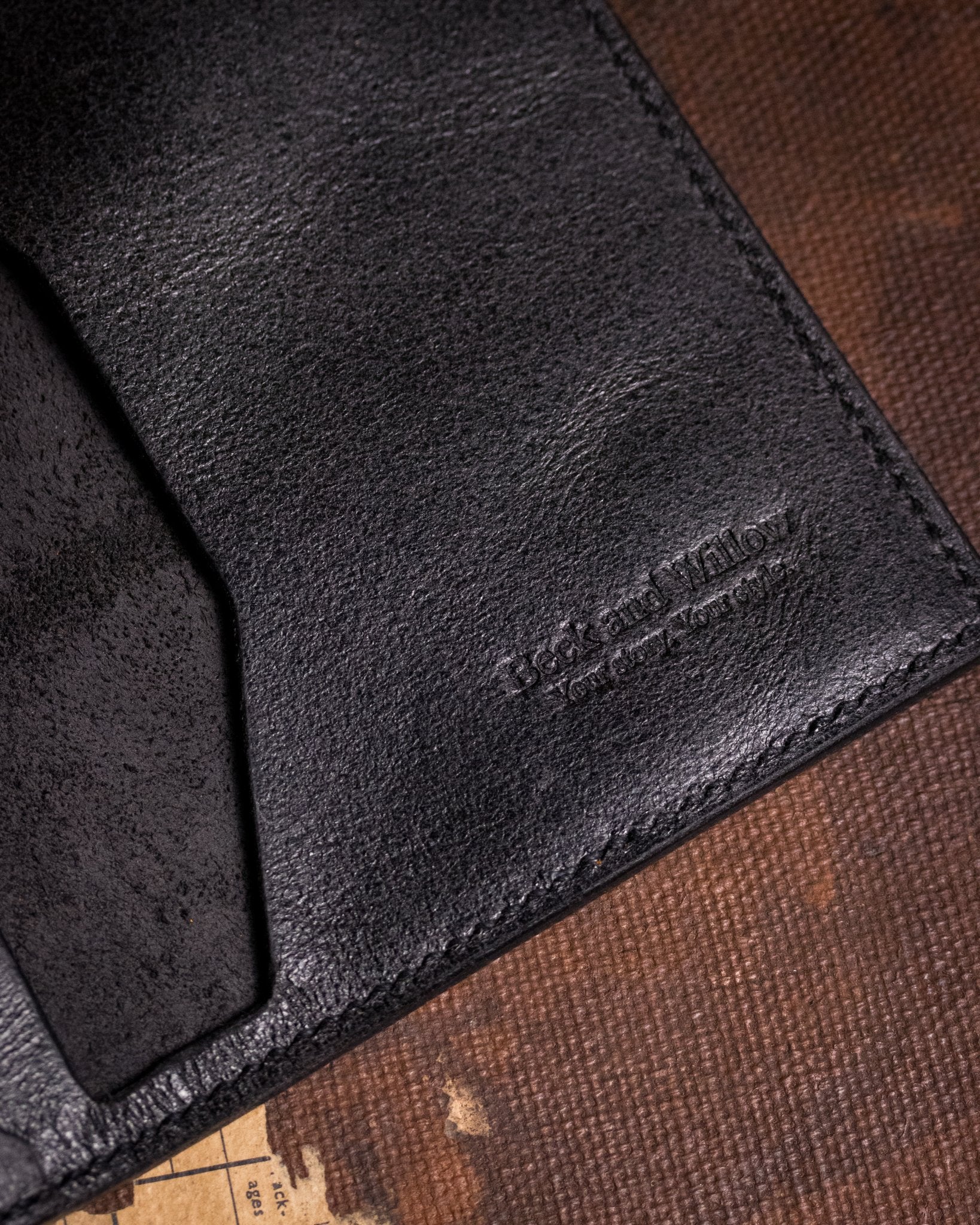 closeup shot of brand logo on distressed black leather