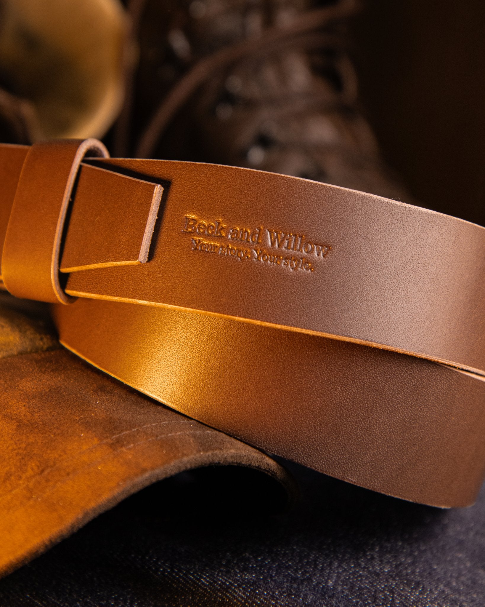 Brown leather belt with 'Beck and Willow' branding on a dark background