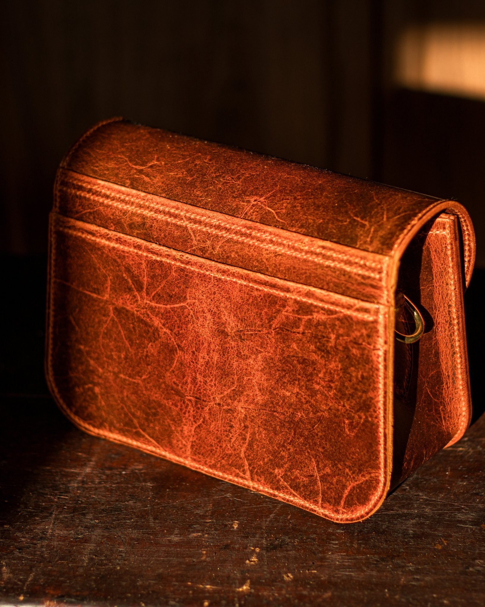 golden sunny picture of the back pocket of a leather crossbody bag