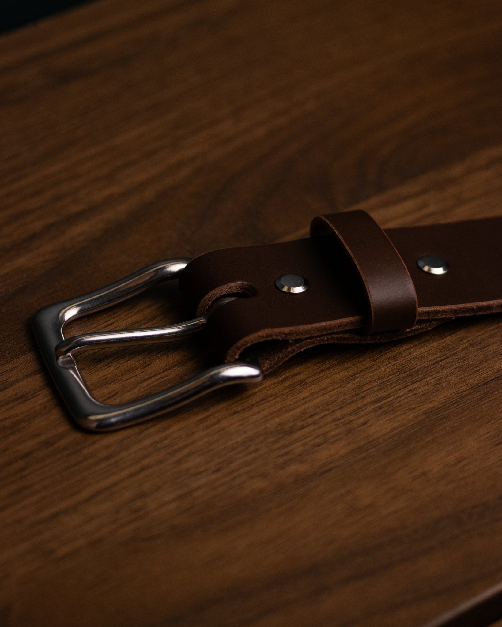 Brown leather belt featuring classic polished steel buckle