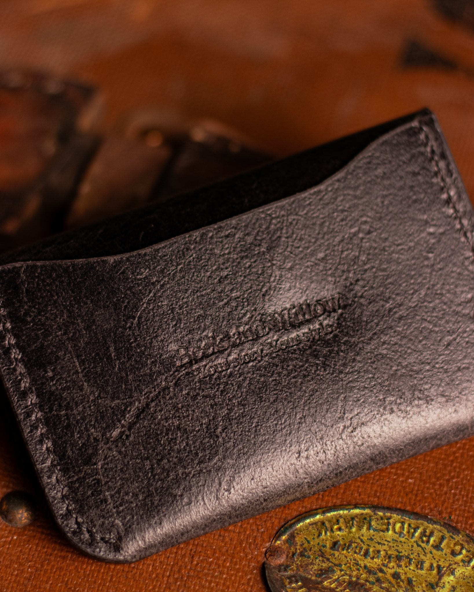 Close Up shot of Brand Logo on a leather card holder in distressed black