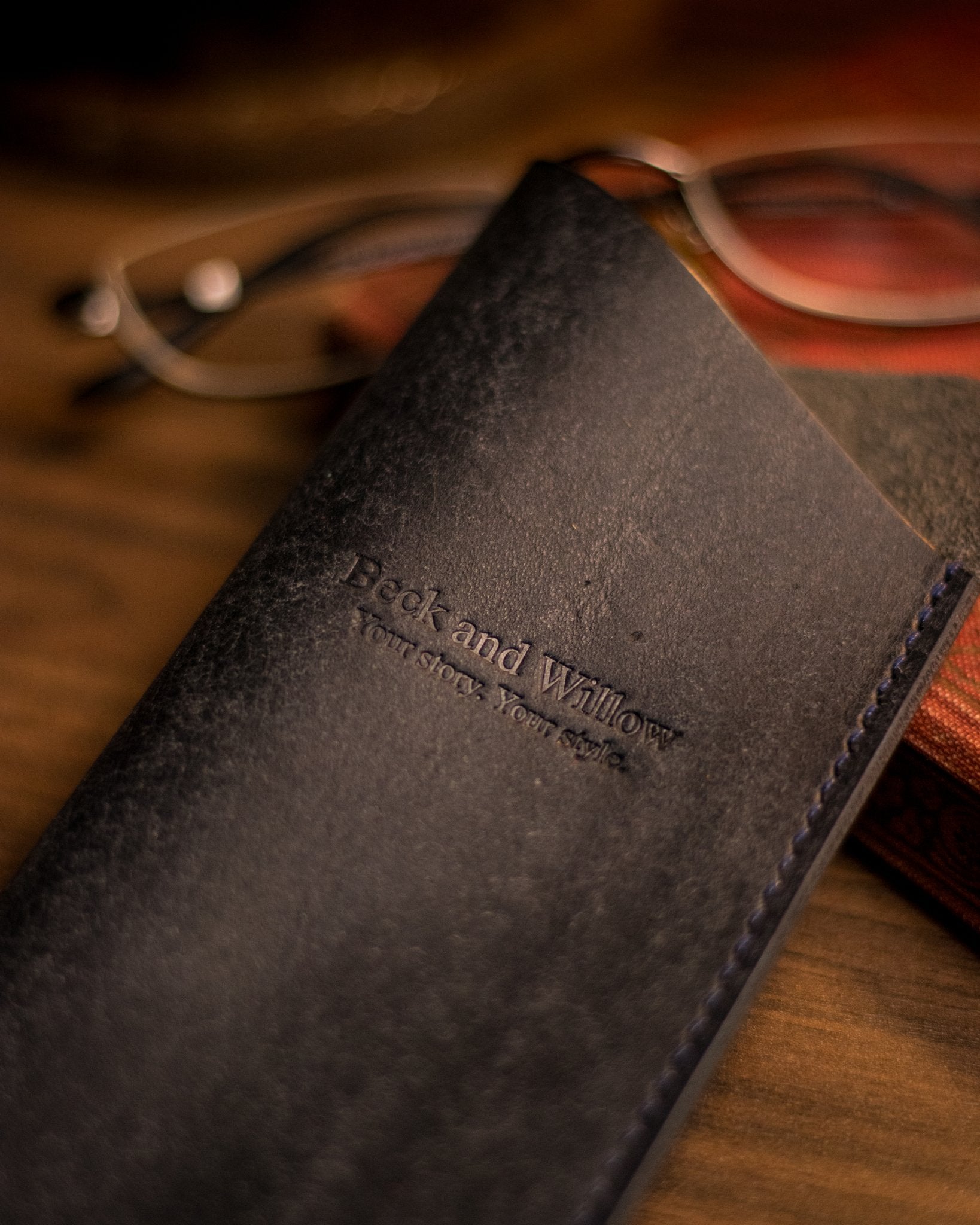 close up photo of brand logo on a navy italian leather glasses sleeve