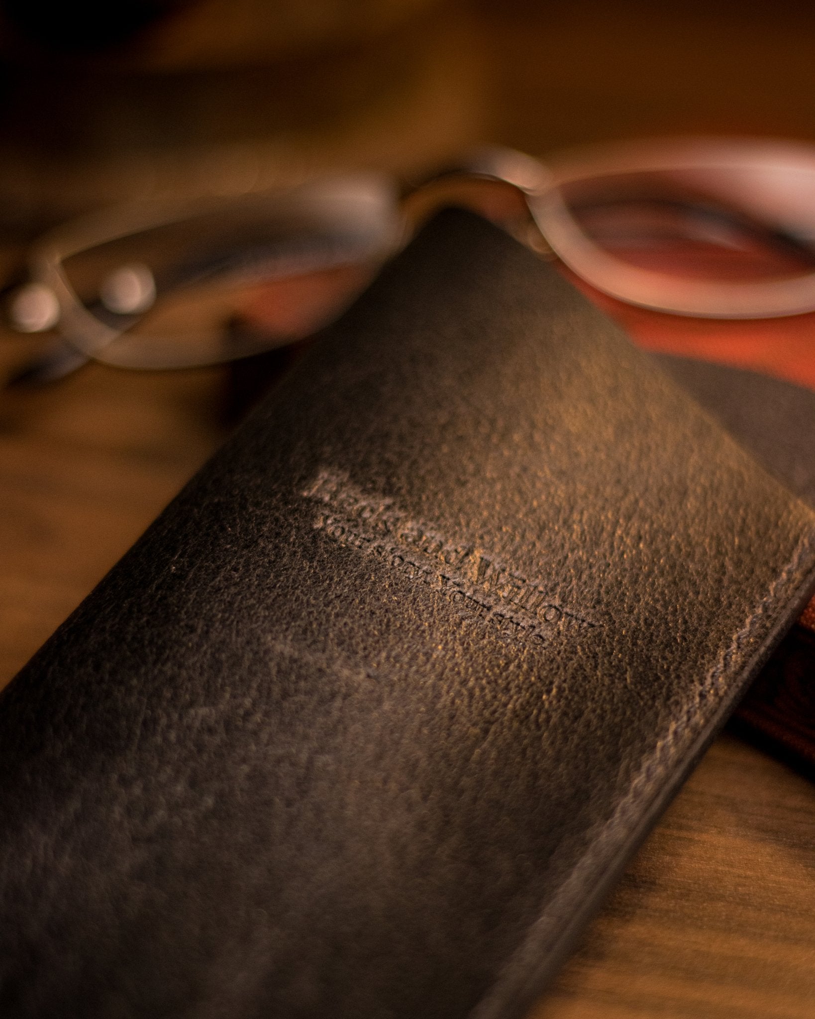 close up shot of brand logo on a black leather glasses case