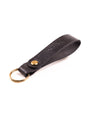 Black Distressed leather keyring with brass hardware on a white background