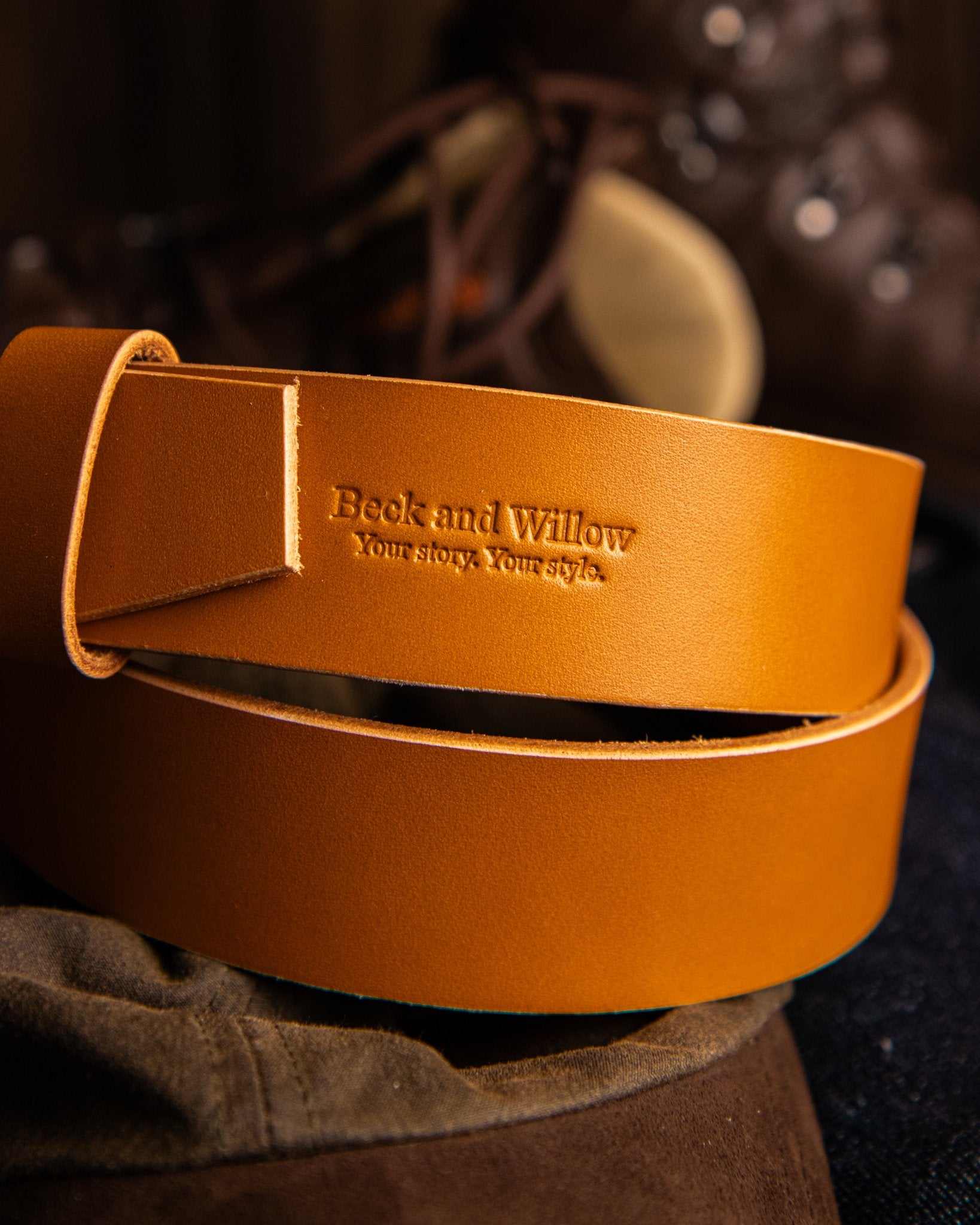 Brown leather belt with 'Beck and Willow' branding on a dark background