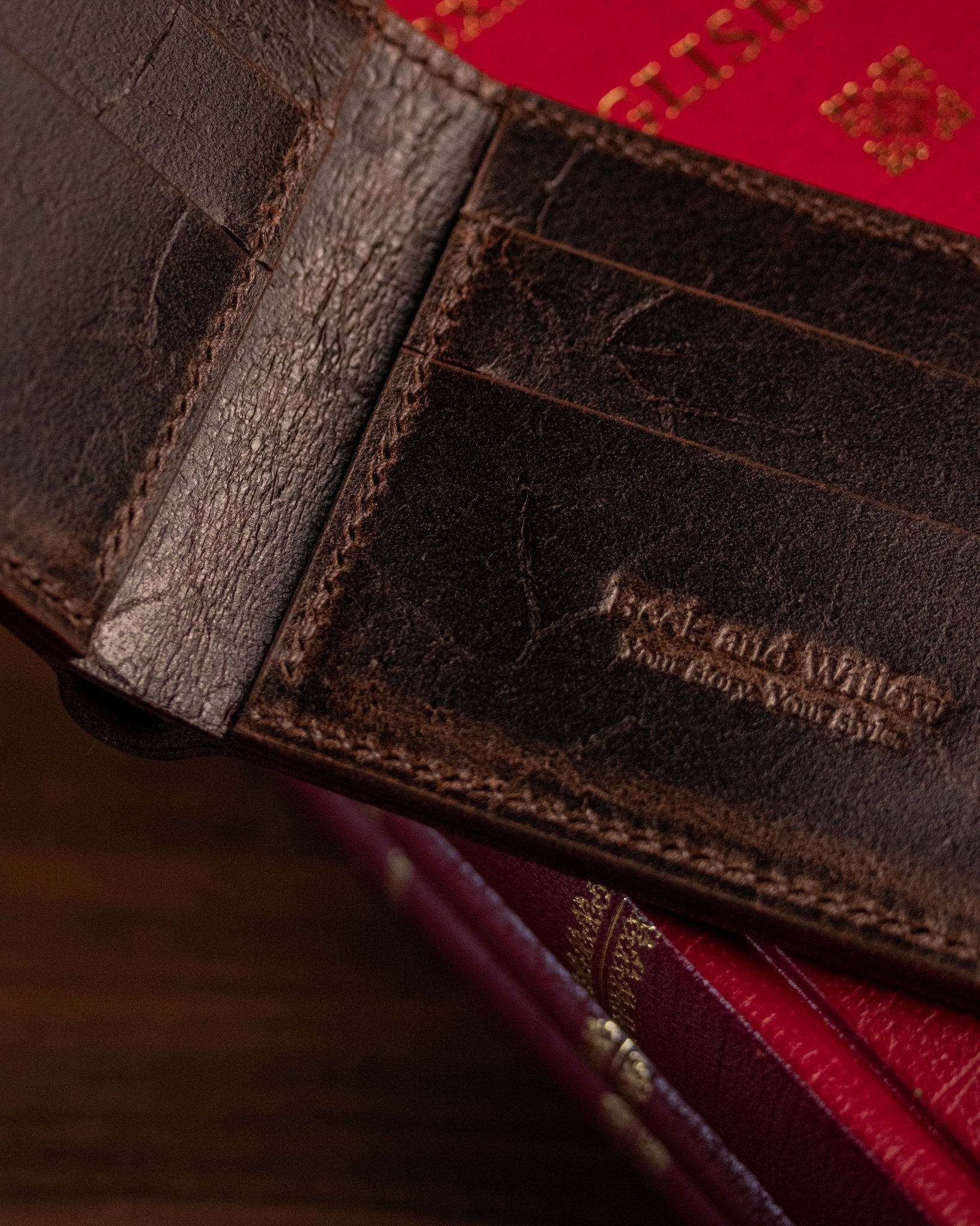 close up detail shot of brand stamp and stitching on a brown wallet