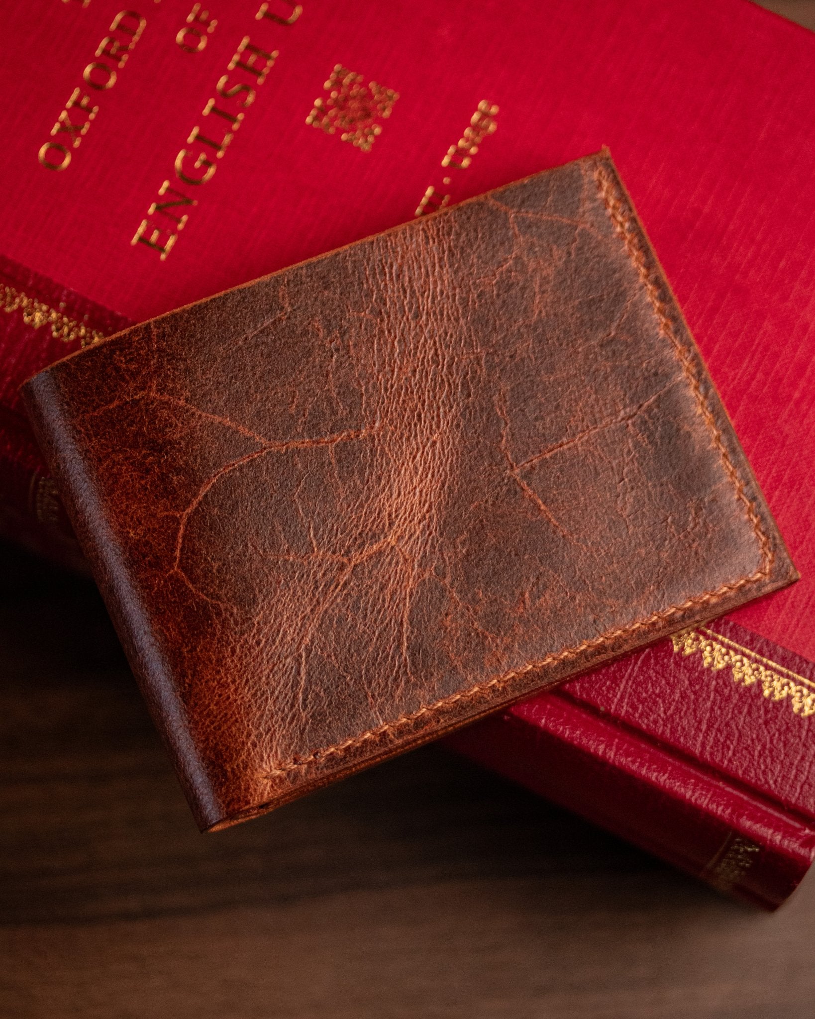 closed distressed tan leather wallet on a book