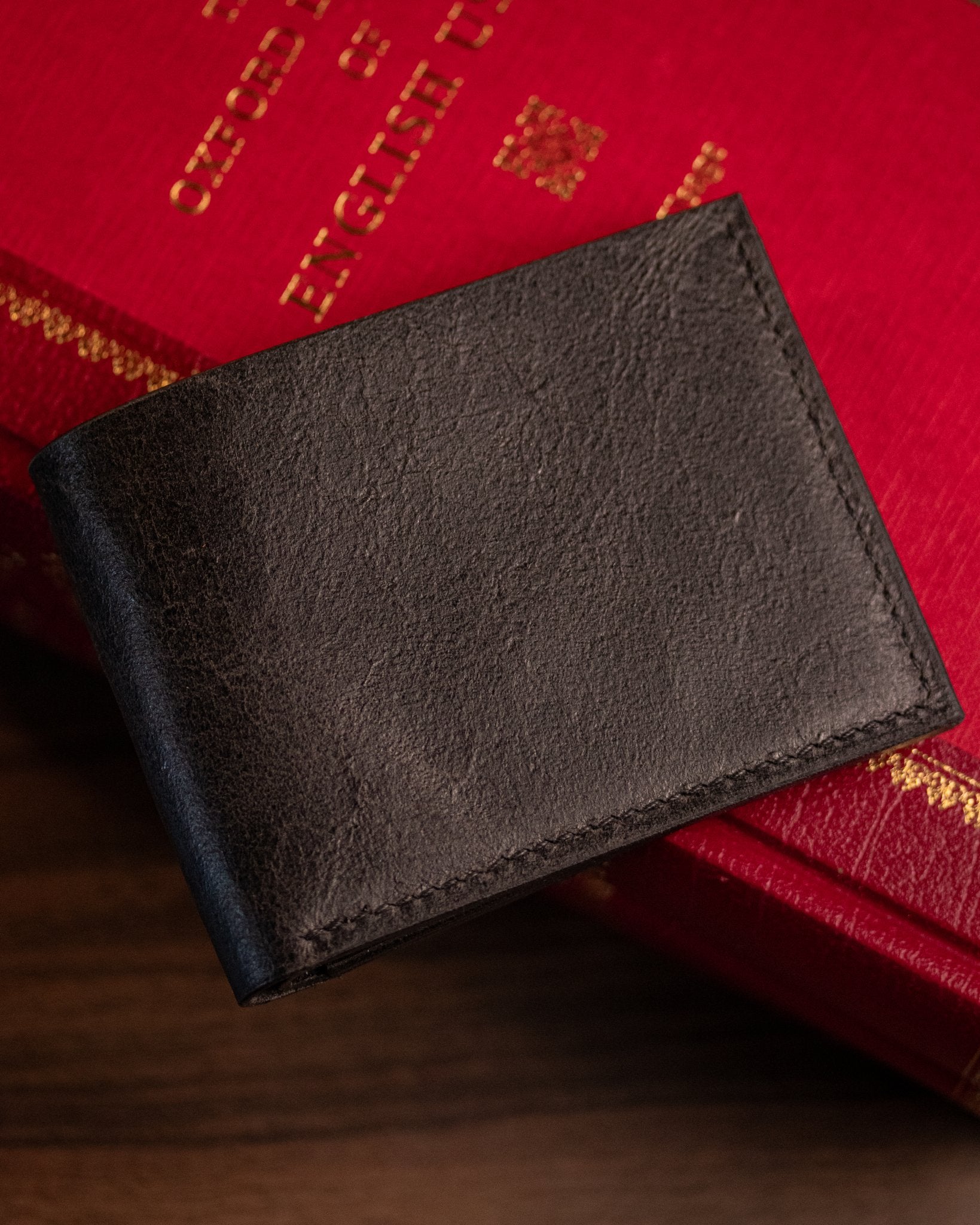 closed distressed black leather wallet on a book